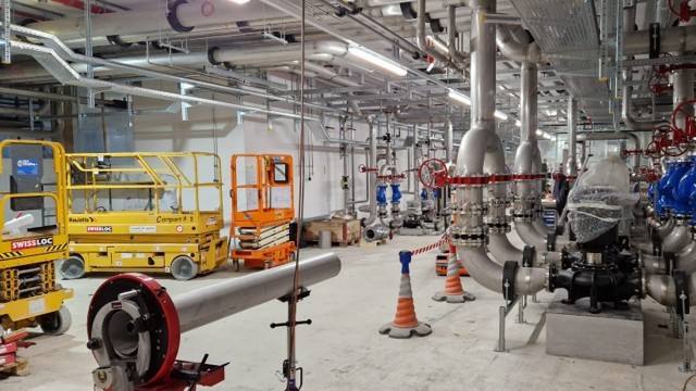 Grande salle technique avec réseaux de tuyauterie inox